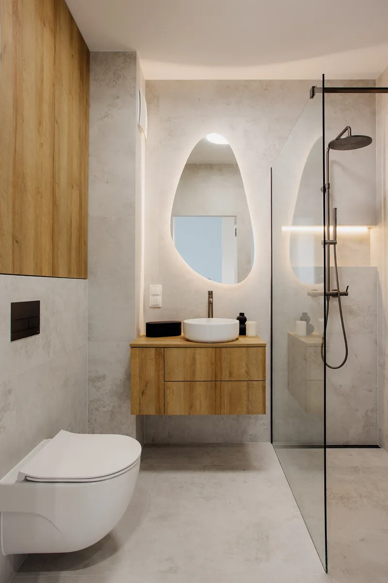 Łazienka z nieregularnym lustrem